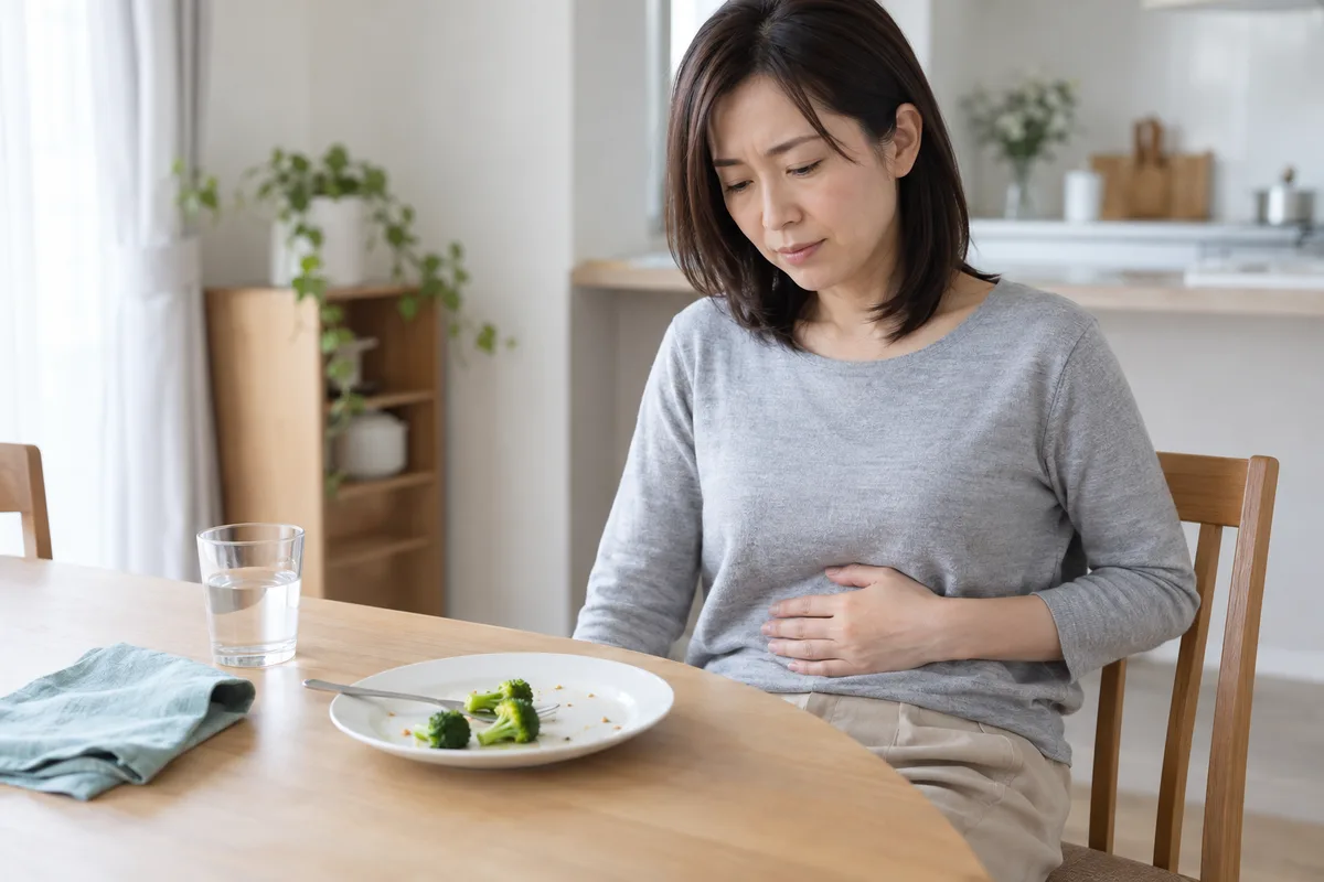 お腹を押さえて不調を感じる女性